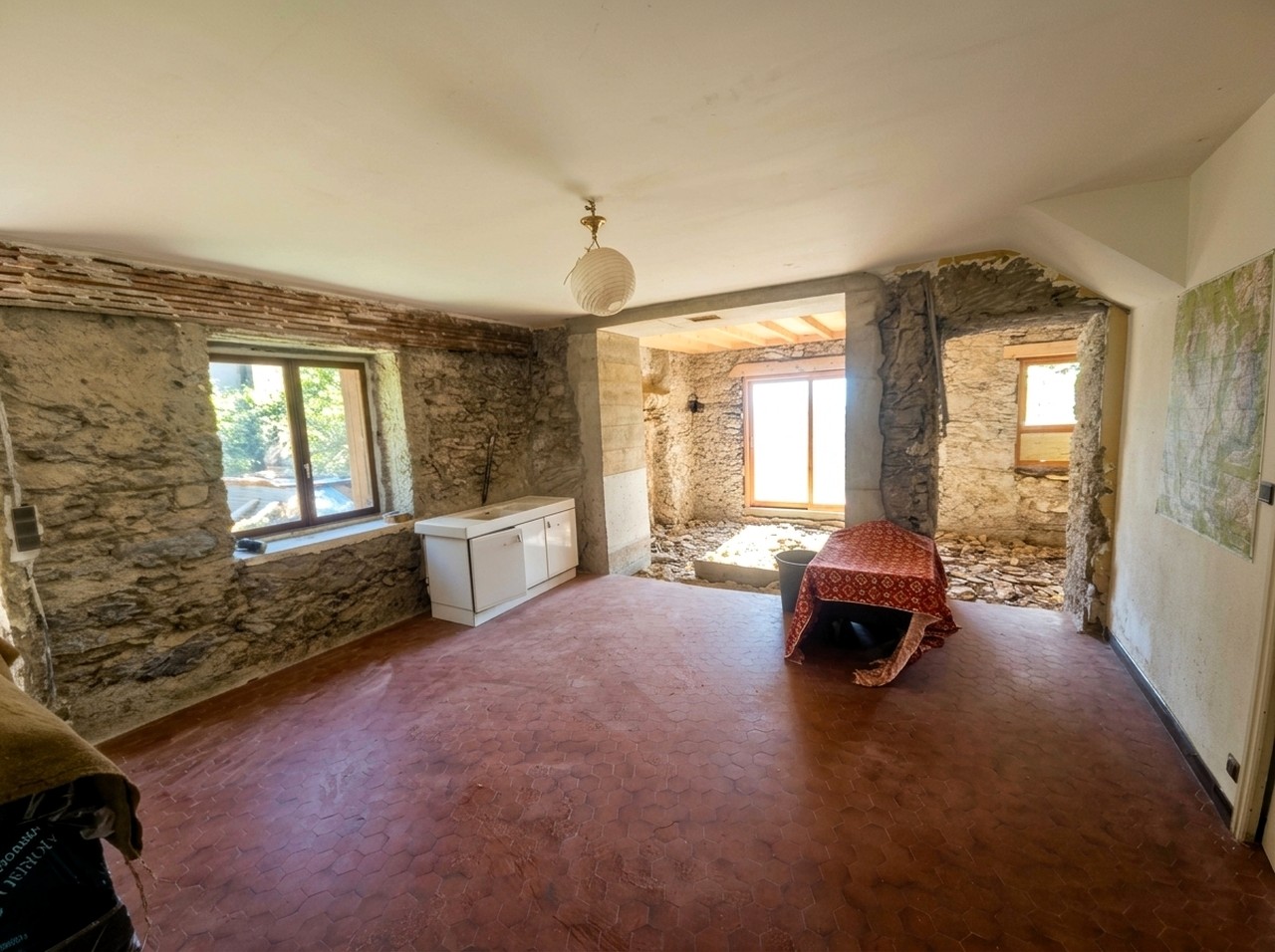Séjour lumineux avec murs en pierre dans une maison ancienne en Matheysine
