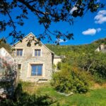 Façade d’une maison ancienne entourée de verdure dans le sud de l’Isère