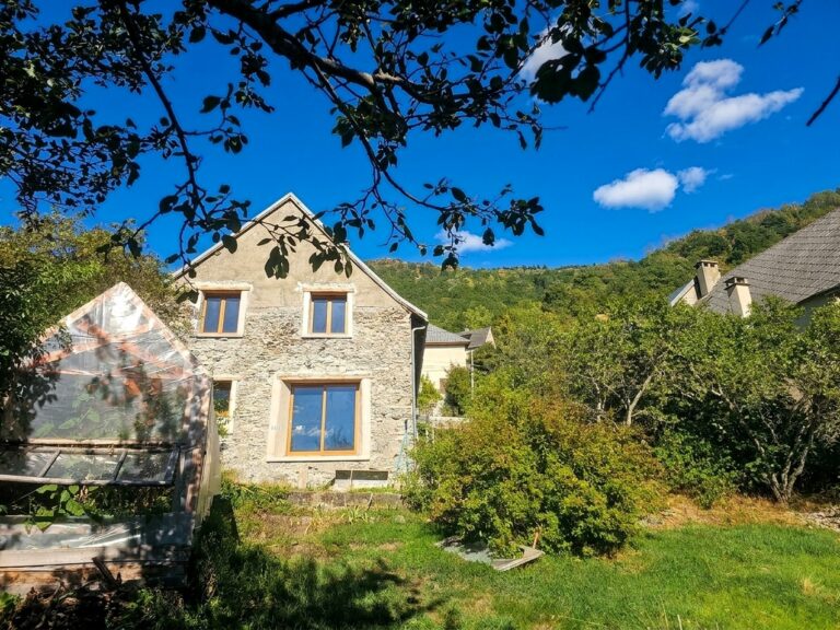 Façade d’une maison ancienne entourée de verdure dans le sud de l’Isère