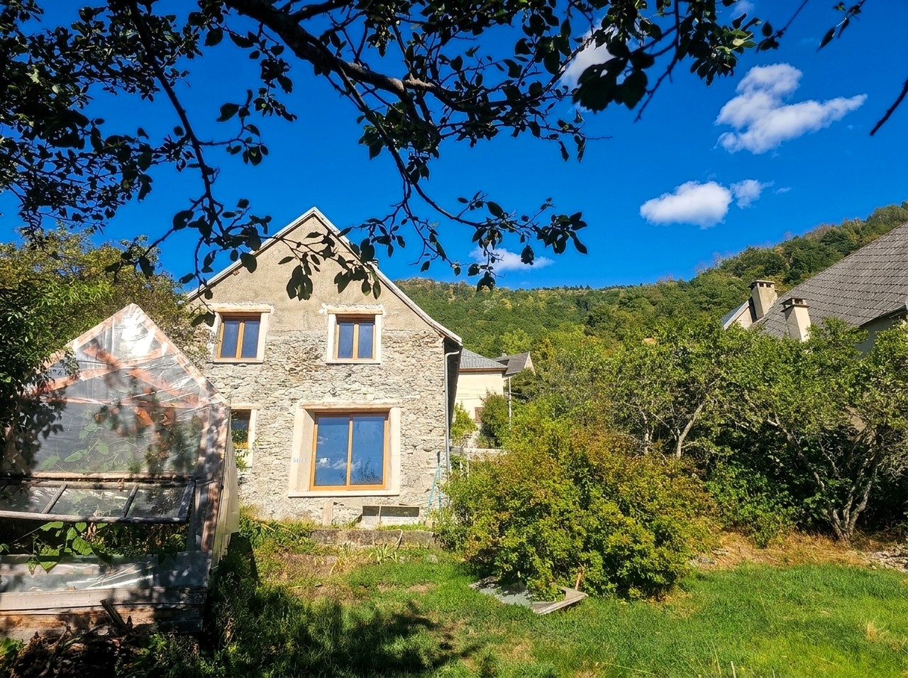 Façade d’une maison ancienne entourée de verdure dans le sud de l’Isère