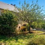 Jardin arboré avec pommier et terrasse d’une maison à vendre en Matheysine
